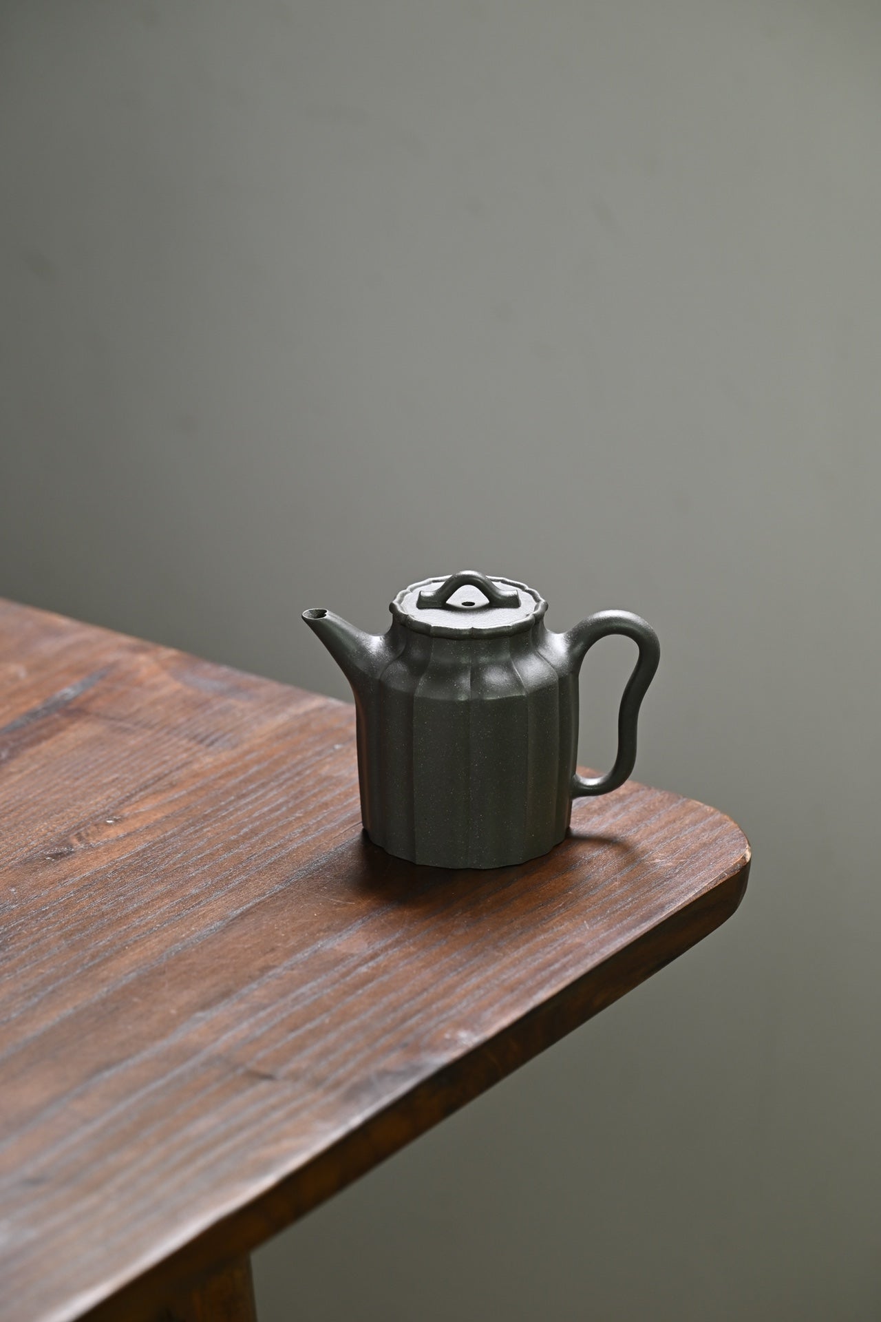 Handmade Yixing purple sand teapot with elegant lines, displayed on a wooden table.