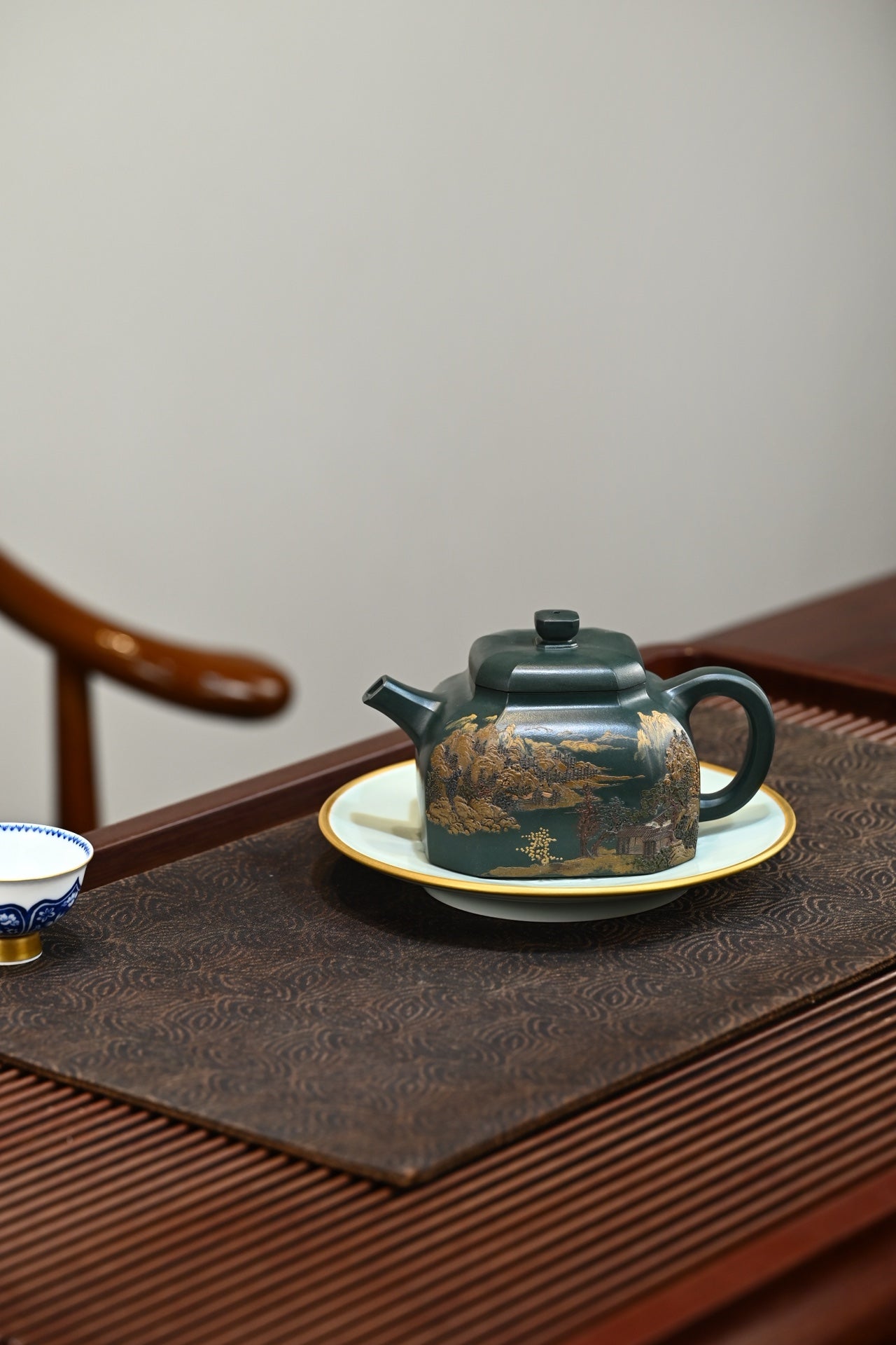 Handmade Yixing purple sand teapot on a fine table setting, showcasing traditional craftsmanship and elegance.