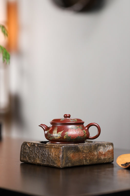 Handmade Yixing purple sand teapot on a wooden base, featuring intricate floral designs.