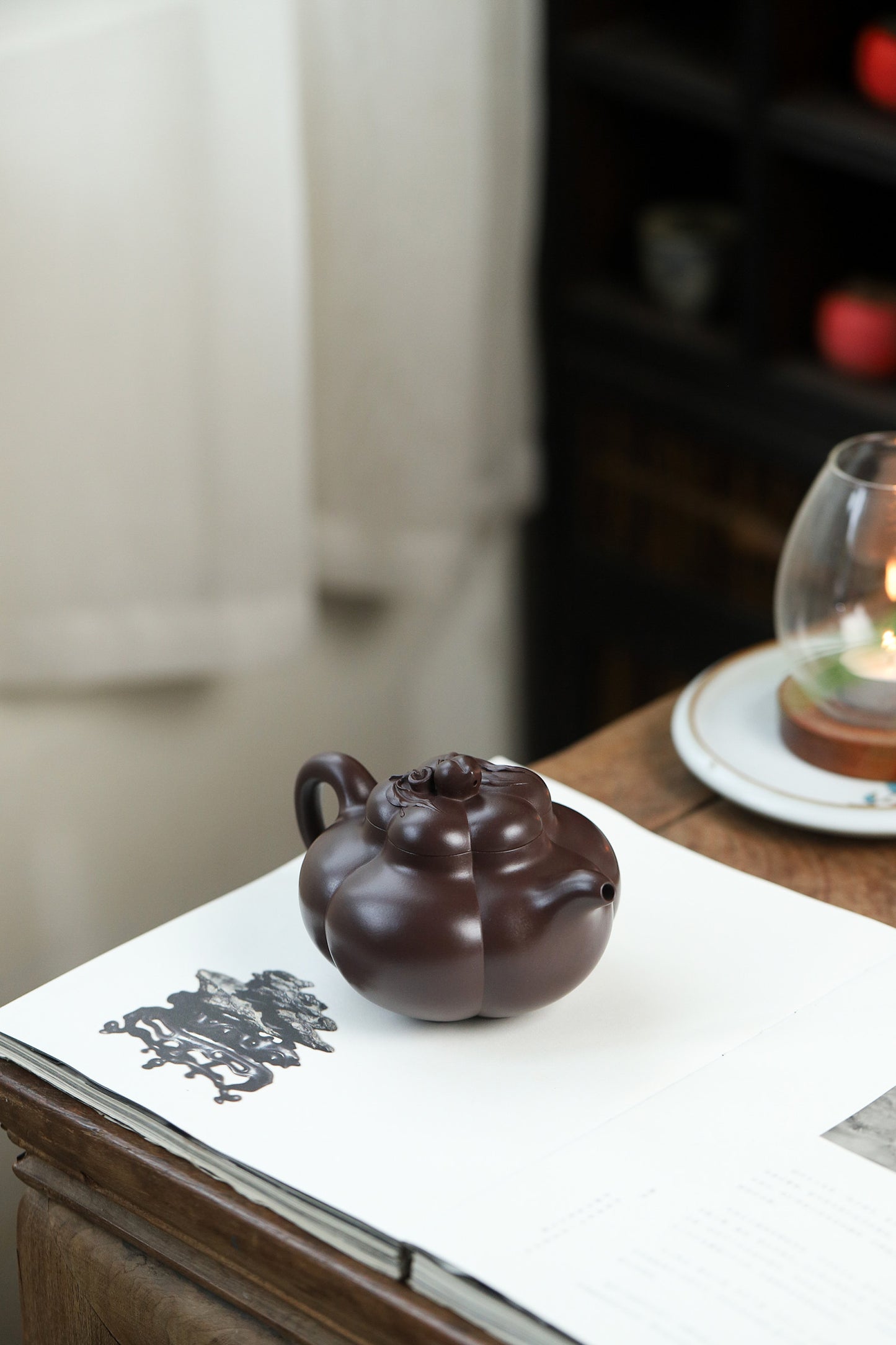 Handmade Yixing purple sand teapot on a table, showcasing elegant design and craftsmanship.