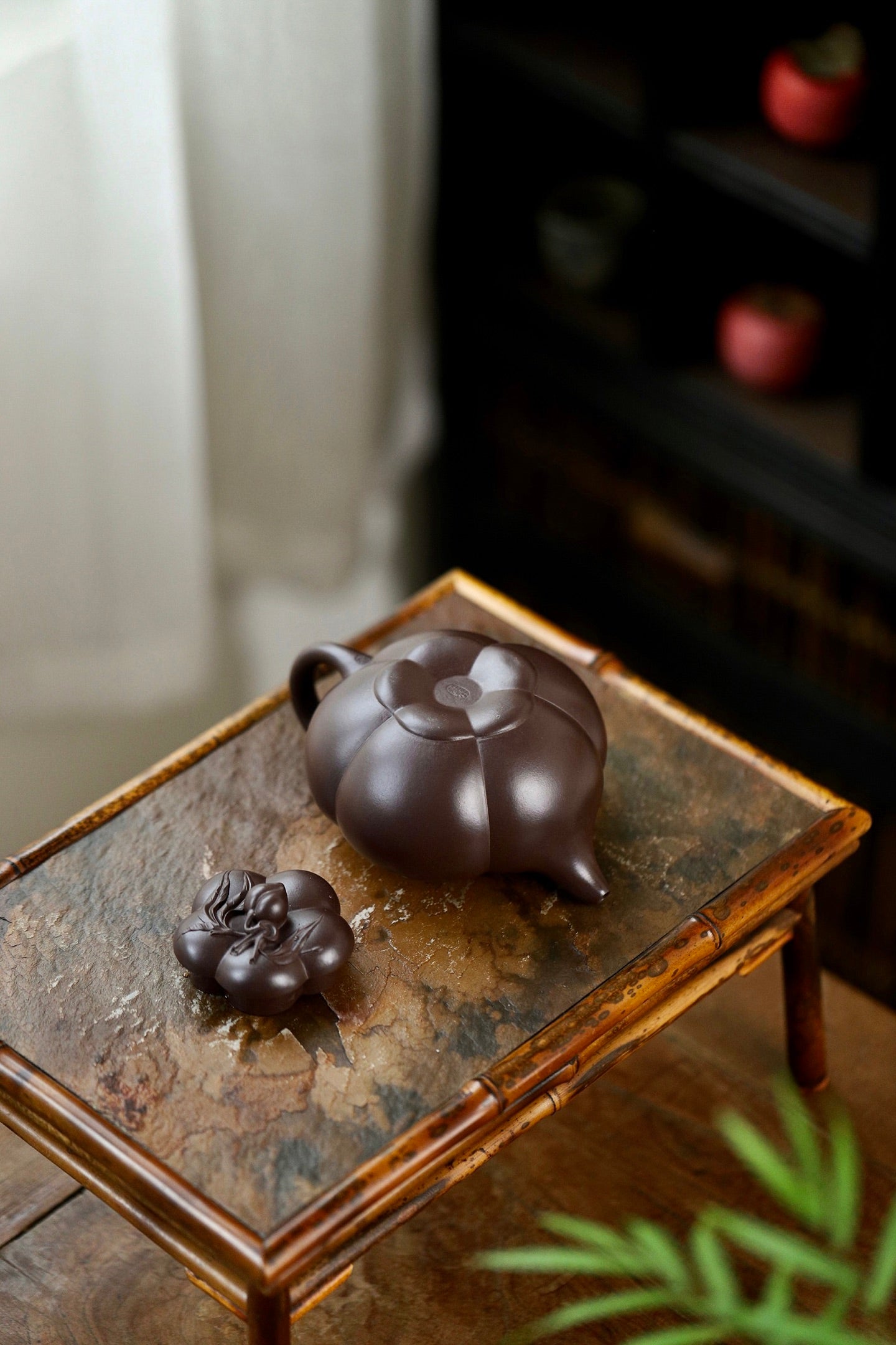 Handmade Yixing purple sand teapot and lid on a wooden table, showcasing elegant design and craftsmanship.