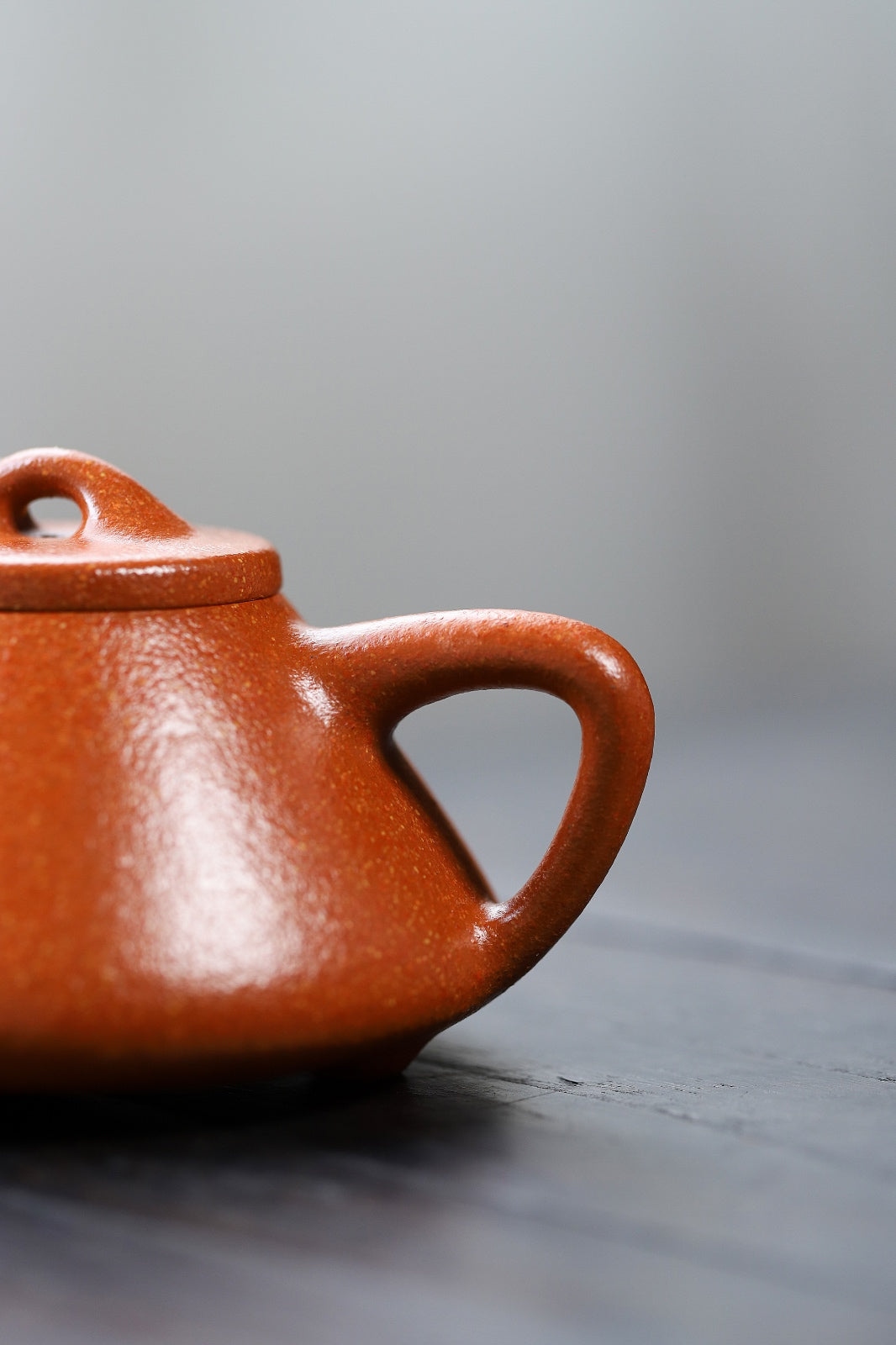 Handmade Yixing purple sand teapot showcasing a glossy red finish and elegant design, perfect for tea enthusiasts.