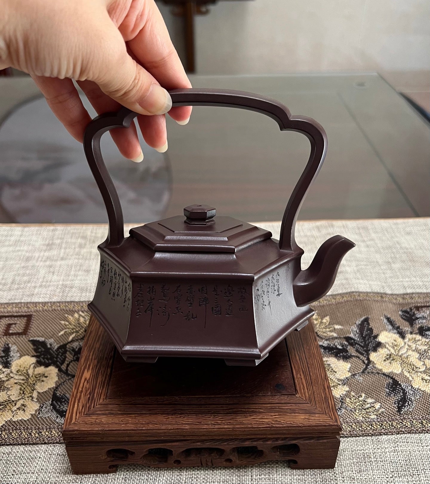 Handmade Yixing purple sand teapot with a hexagonal shape and decorative handle, showcasing classical craftsmanship.