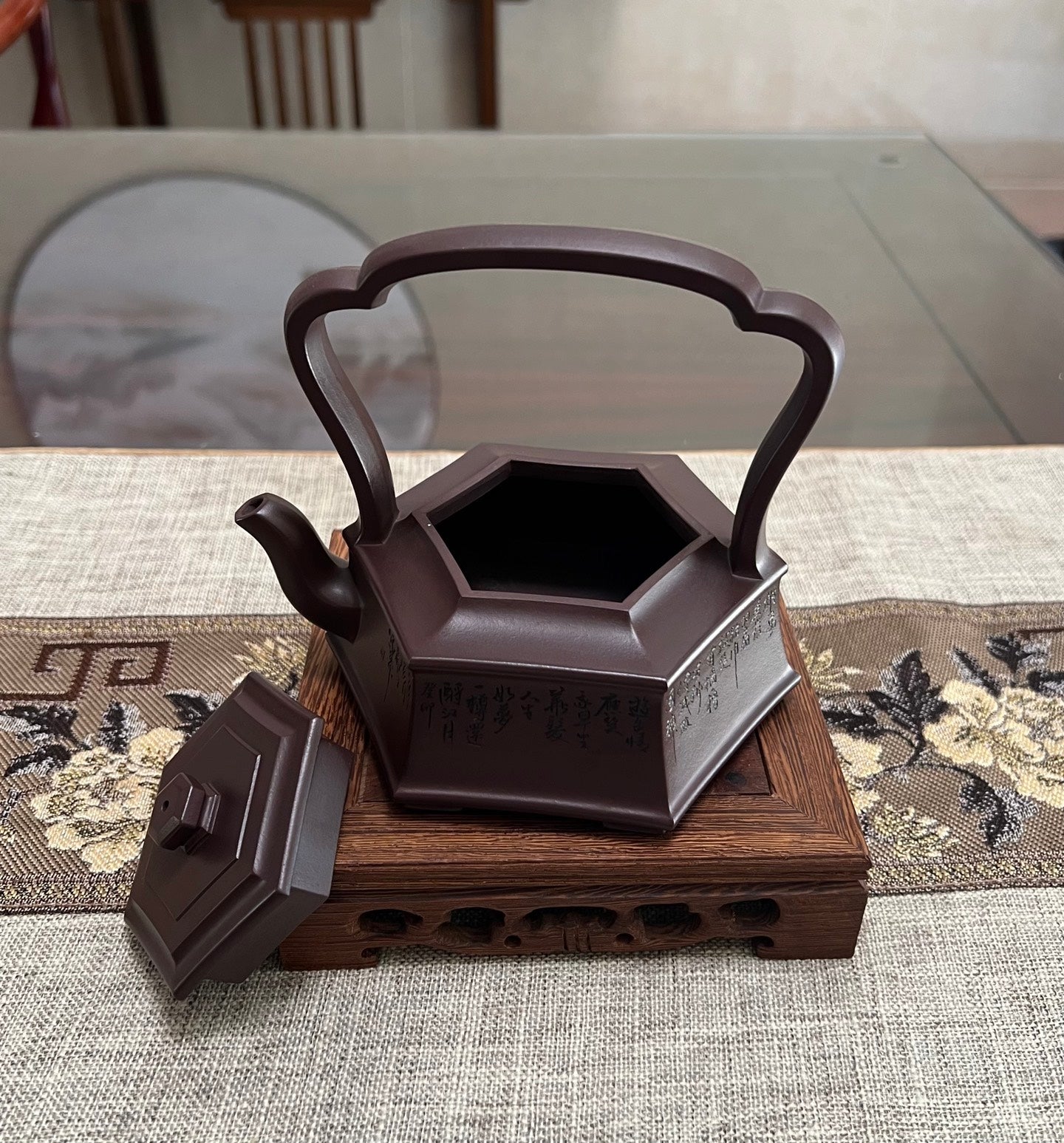 Handmade Yixing purple sand teapot with hexagonal body and extended handle, showcasing detailed craftsmanship.
