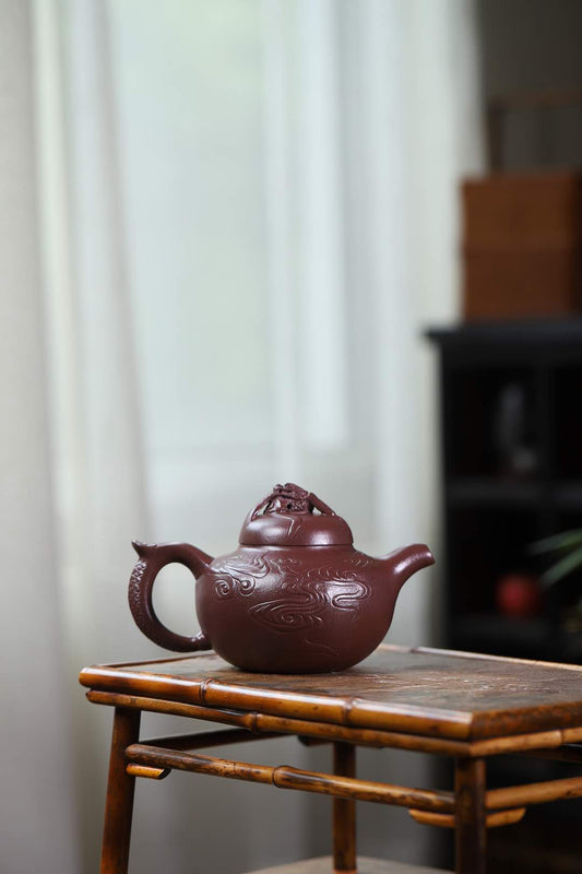 Handmade Yixing purple sand teapot, featuring classic design and intricate detailing on the surface.