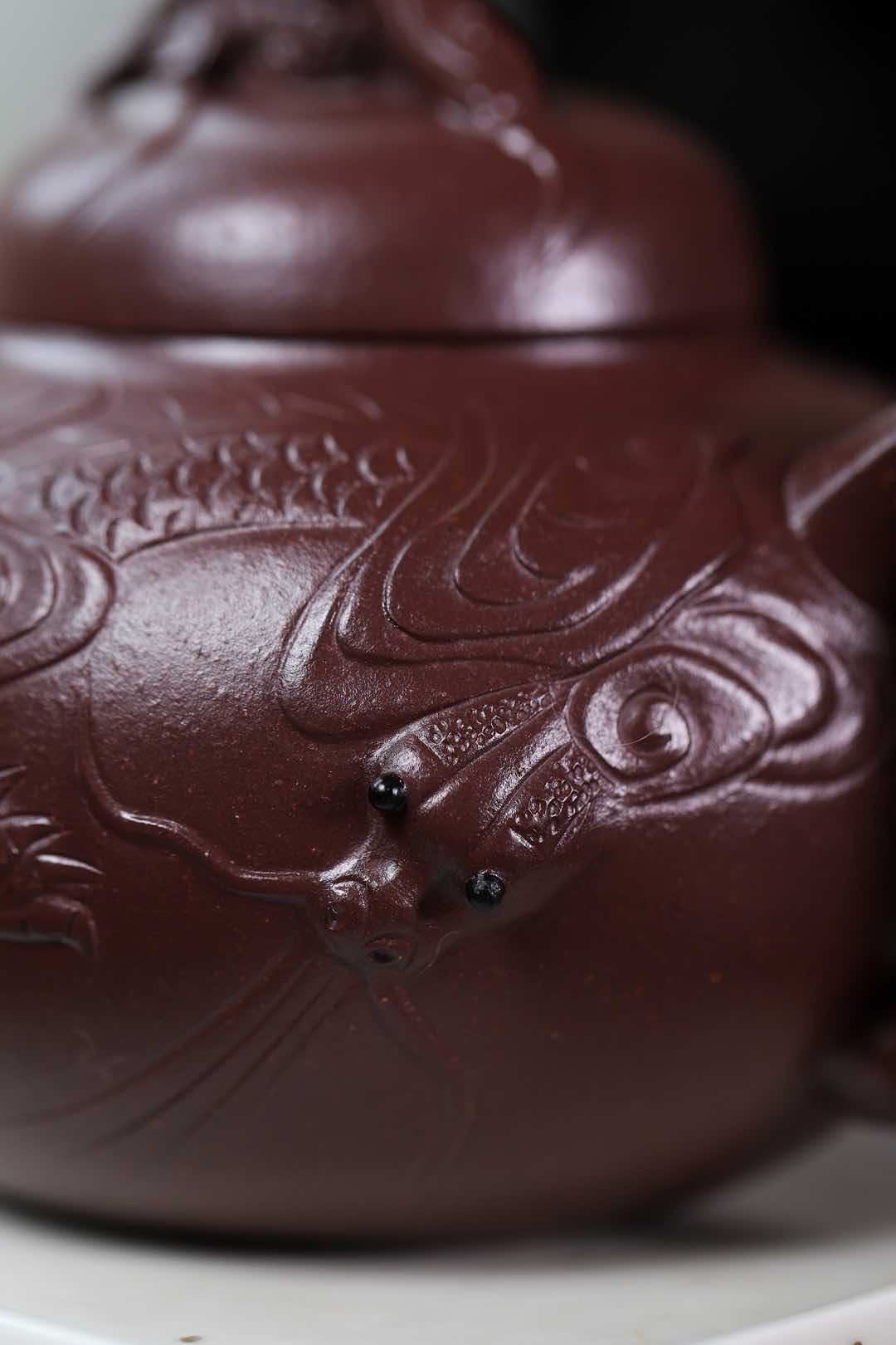 Handmade Yixing purple sand teapot with dragon design, showcasing intricate craftsmanship and traditional art.