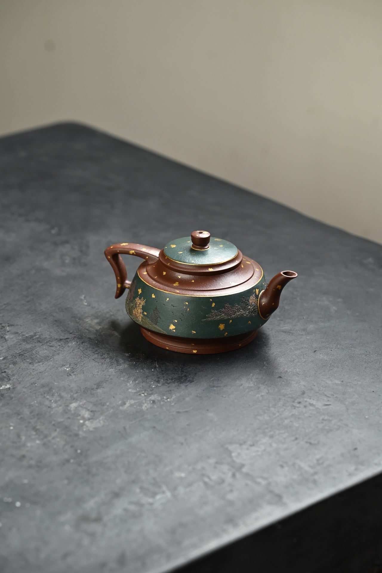 Handmade Yixing purple sand teapot featuring elegant design with green and gold accents, crafted by skilled artisans.