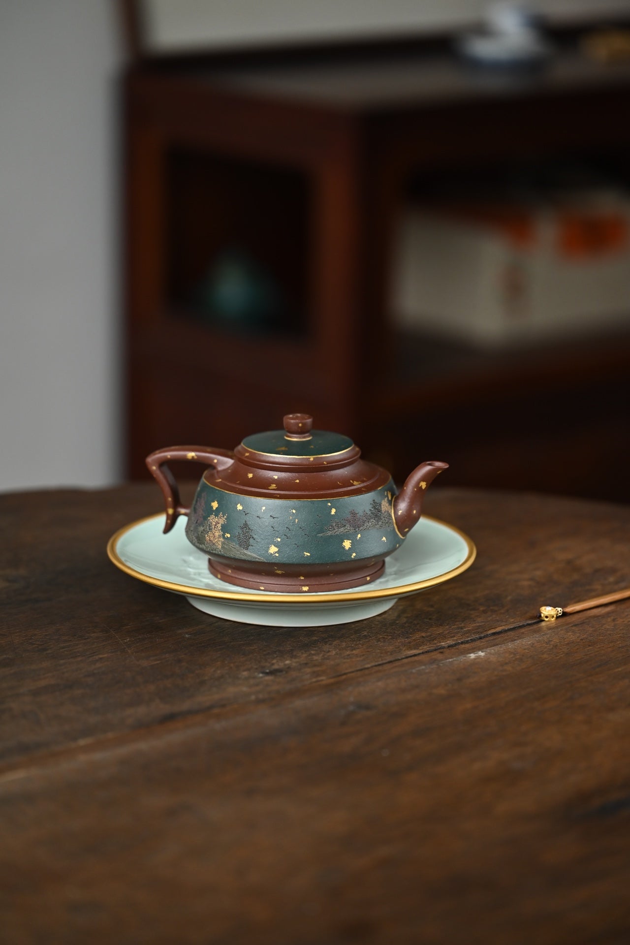 Handmade Yixing purple sand teapot on saucer, showcasing elegant craftsmanship and traditional design.