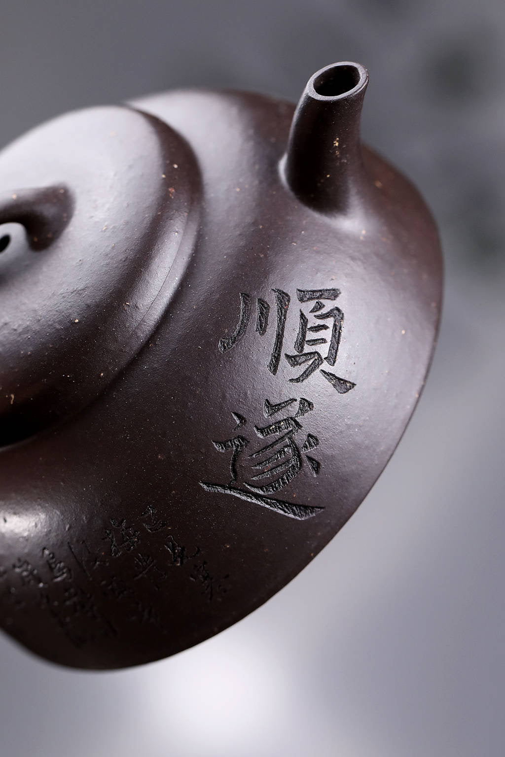 Handmade Yixing purple sand teapot with intricate inscriptions, showcasing traditional craftsmanship.