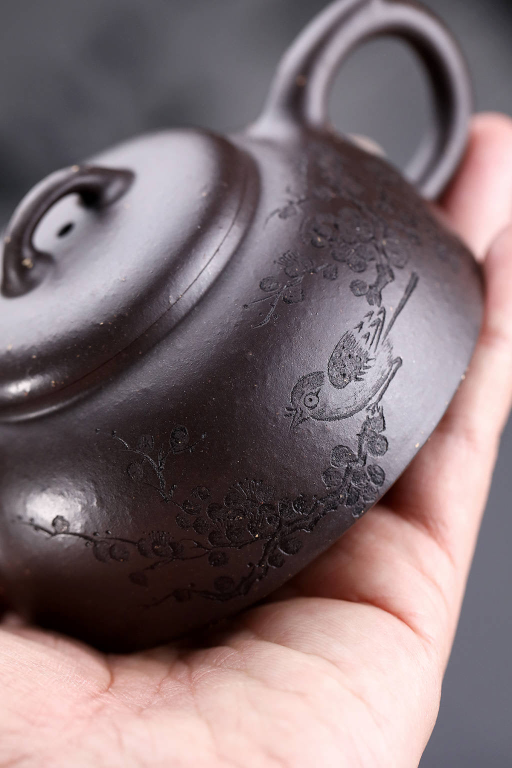Handmade Yixing purple sand teapot with bird design, showcasing intricate craftsmanship and traditional artistry.