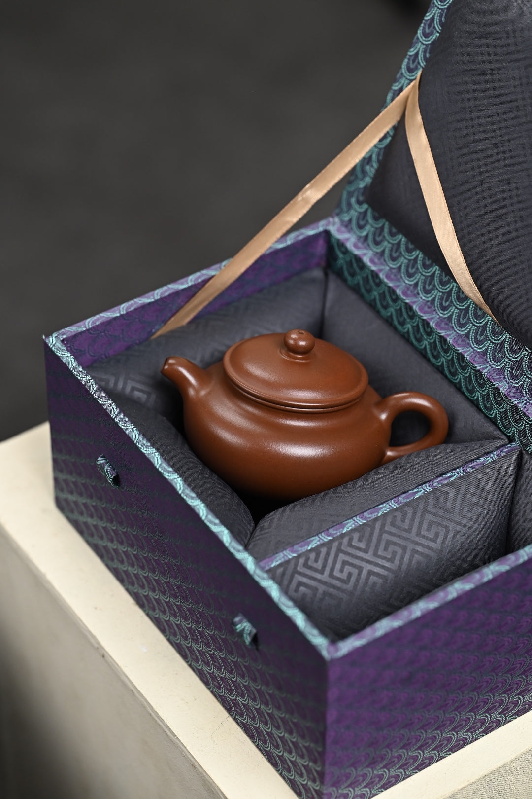 Handmade Yixing purple sand teapot in decorative gift box, showcasing authentic craftsmanship and elegant packaging.