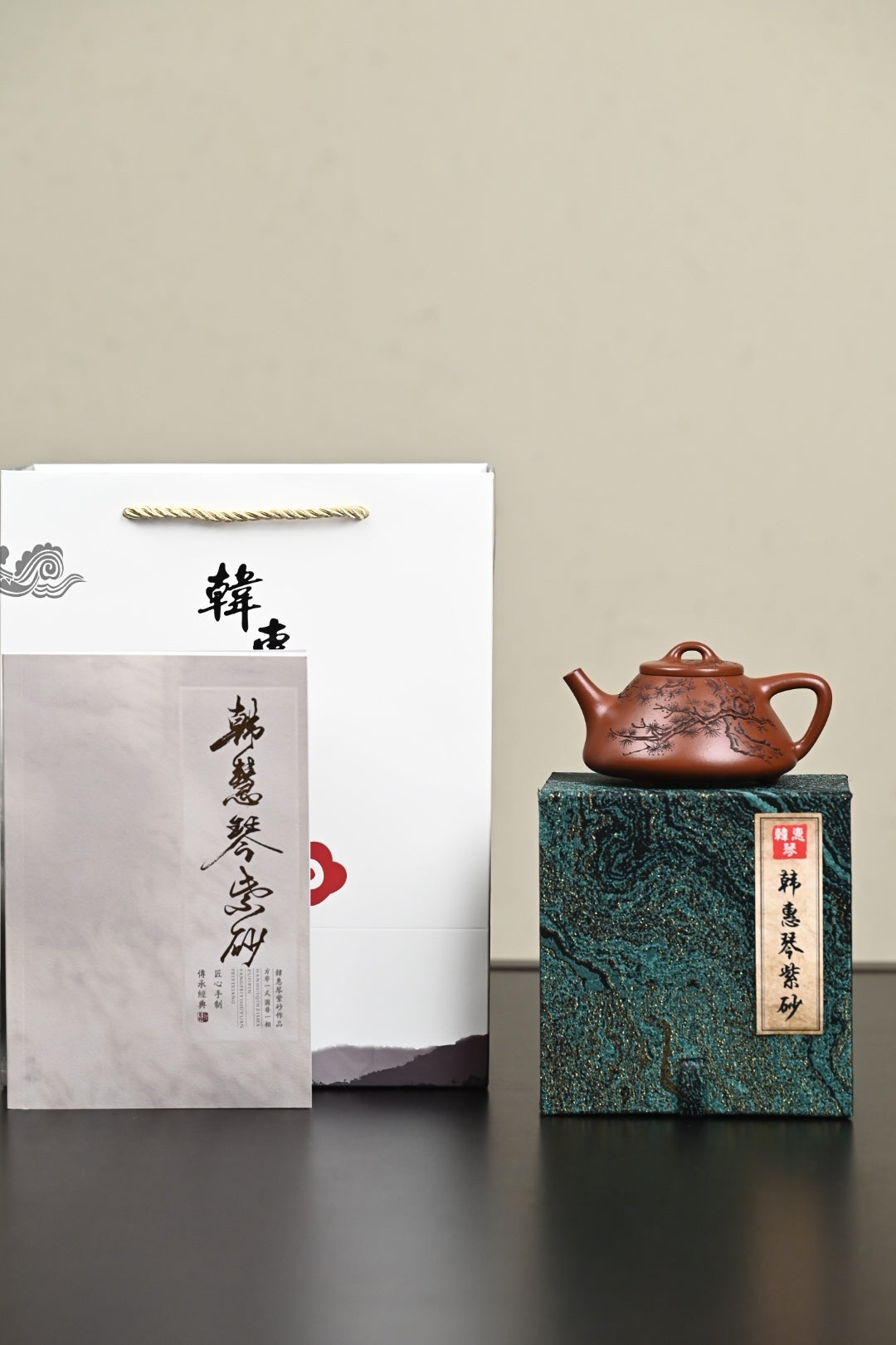 Handmade Yixing purple sand teapot displayed with a gift box and certificate of authenticity.