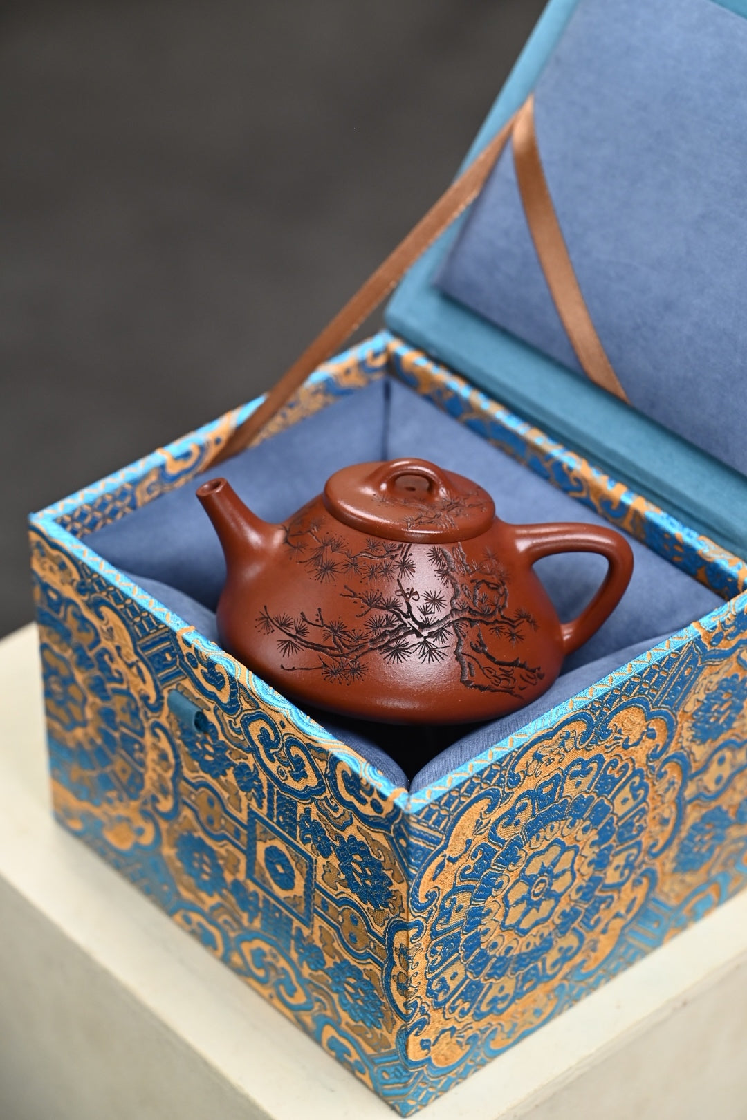 Handmade Yixing purple sand teapot in decorative gift box, showcasing intricate design and craftsmanship.