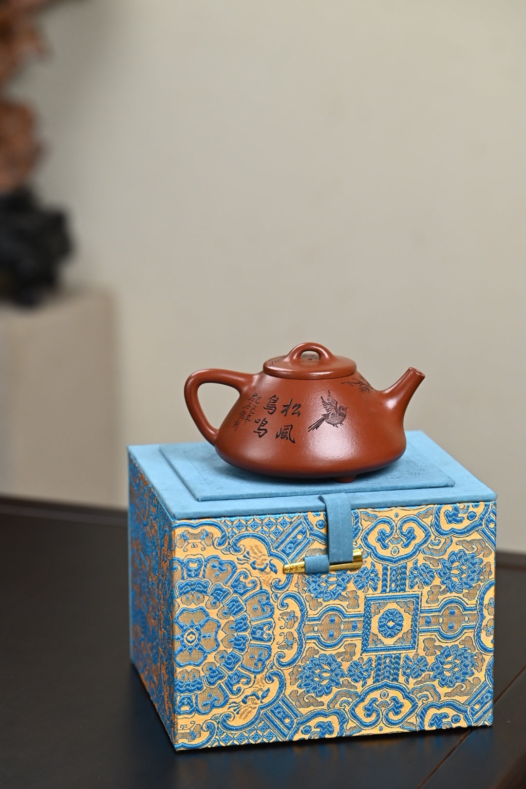 Handmade Yixing purple sand teapot on decorative gift box, showcasing traditional craftsmanship.