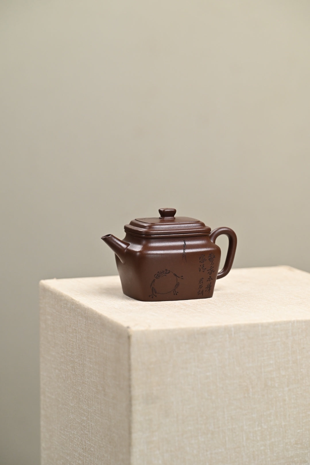 Handmade Yixing purple sand teapot on display, showcasing intricate craftsmanship and rich color.