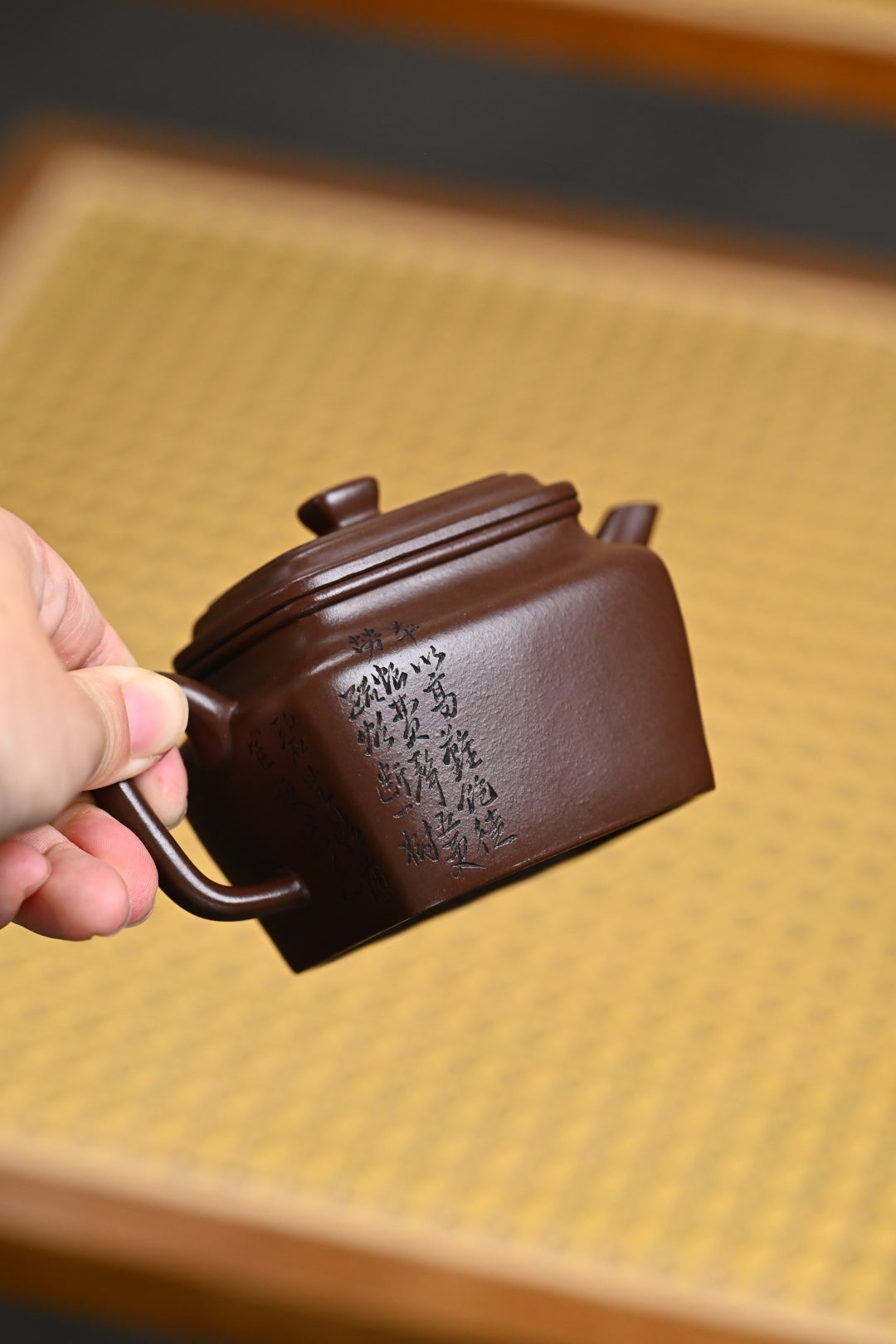 Handmade Yixing purple sand teapot with inscriptions, showcasing craftsmanship in traditional tea culture.