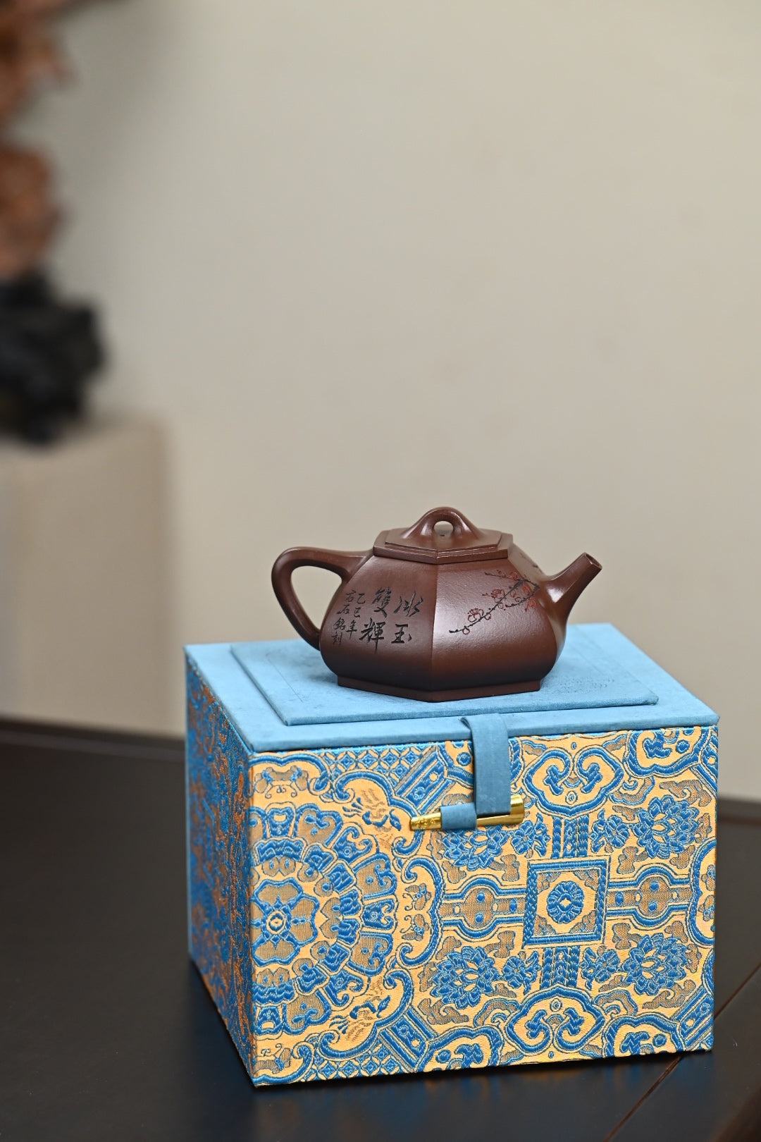 Handmade Yixing purple sand teapot on decorative blue gift box, showcasing exquisite craftsmanship.