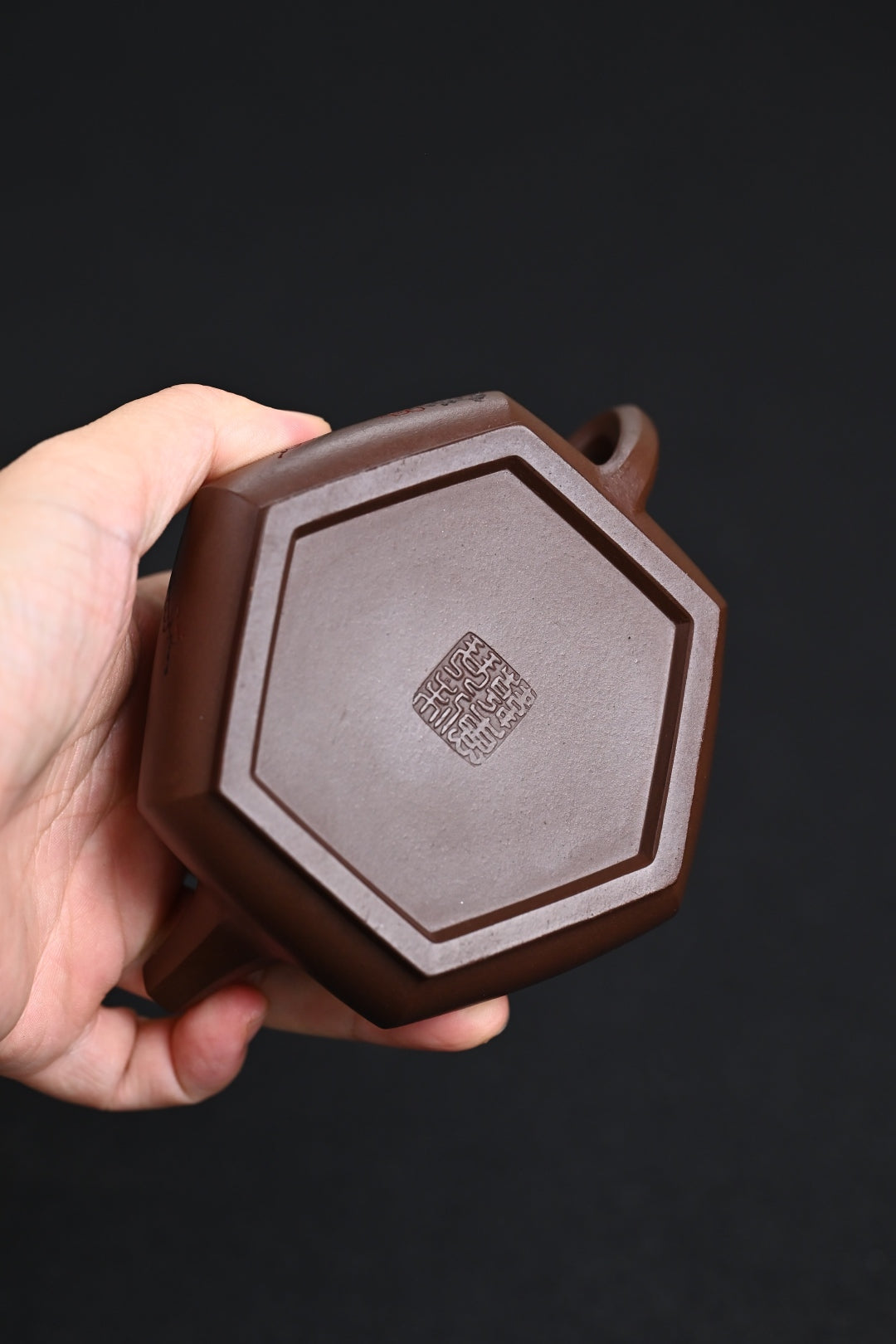 Handmade Yixing purple sand teapot, hexagonal design, showcasing traditional craftsmanship and unique texture.