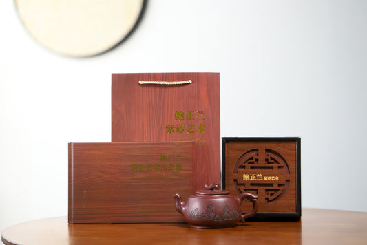 Handmade Yixing purple sand teapot with elegant wooden packaging on display.