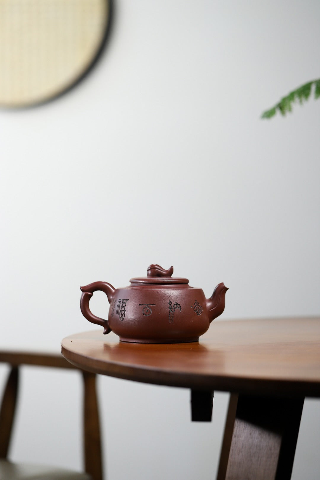 Handmade Yixing purple sand teapot on a wooden table, showcasing traditional craftsmanship and unique design.