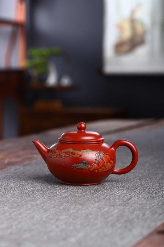 Handmade Yixing purple sand teapot with scenic design, showcasing exquisite craftsmanship and vibrant colors.