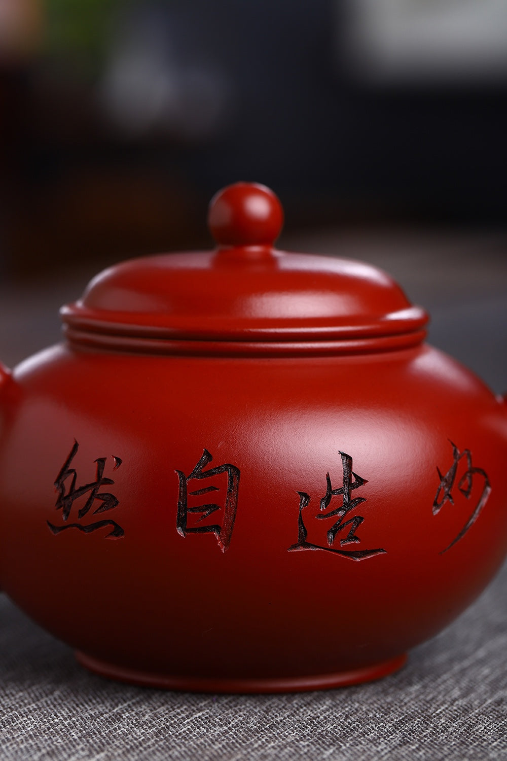 Handmade Yixing purple sand teapot with intricate carvings, showcasing traditional craftsmanship and rich red glaze.