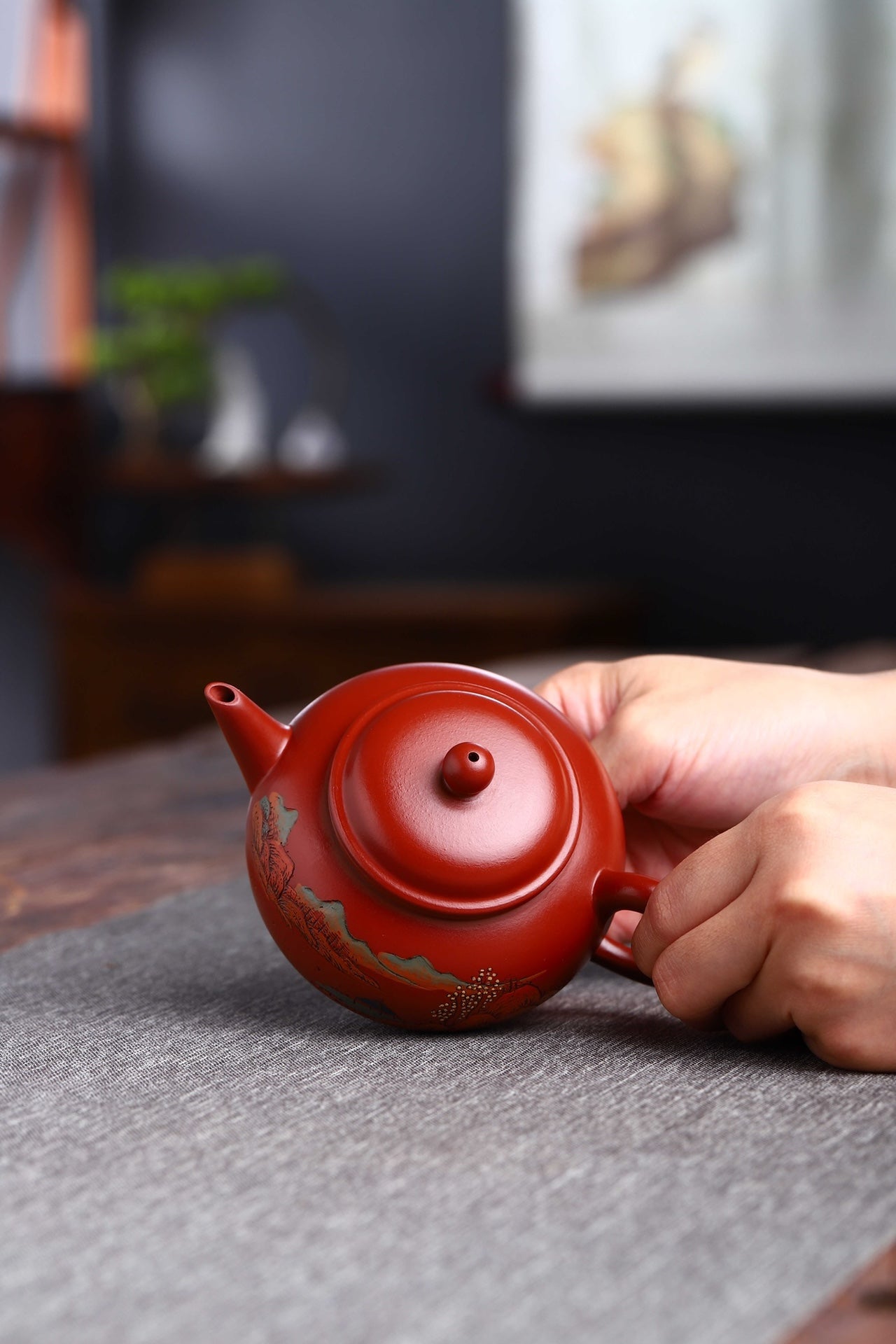 Handmade Yixing purple sand teapot held in hand, showcasing fine craftsmanship and unique design.
