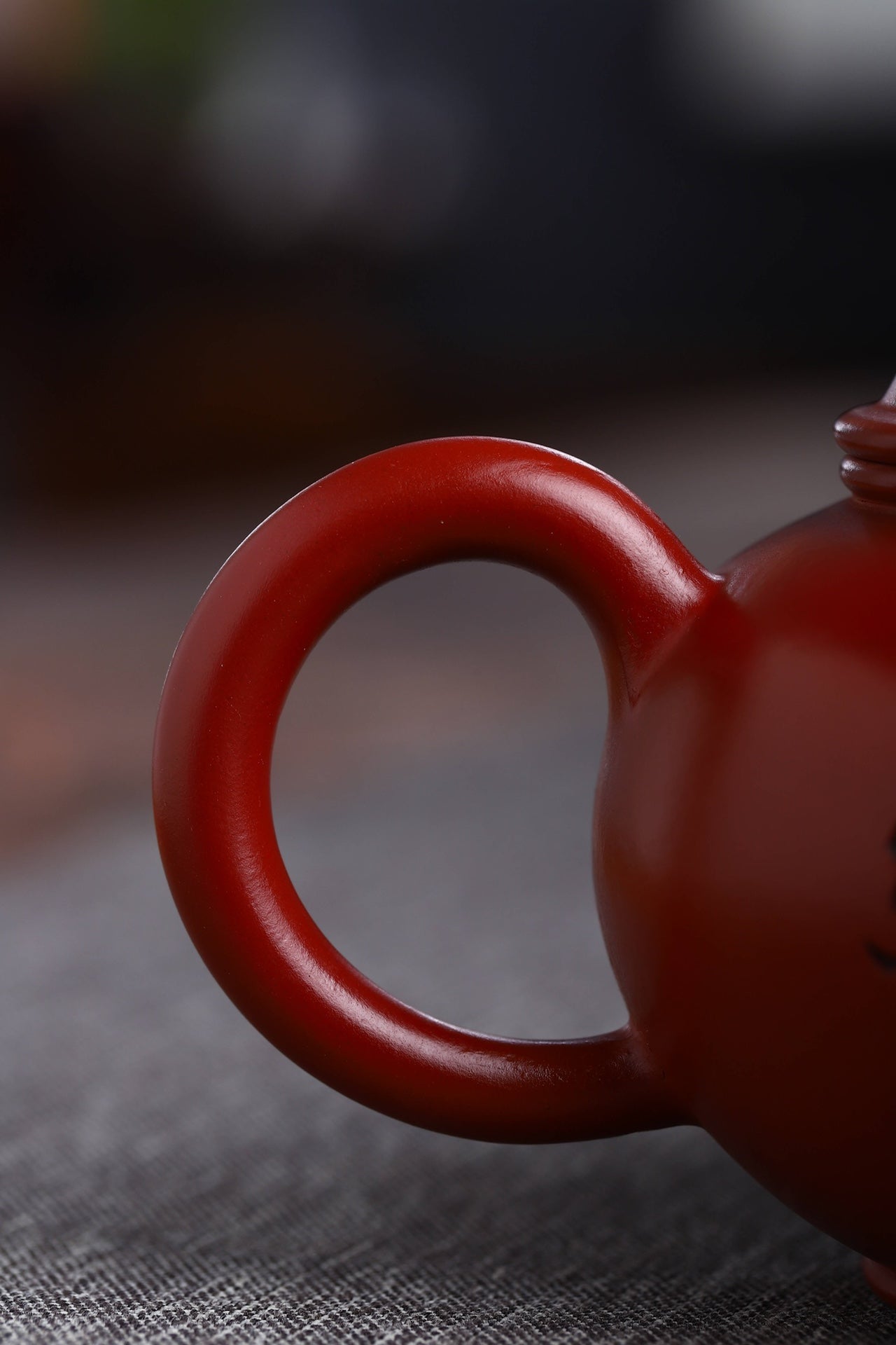 Detailed view of a handmade Yixing purple sand teapot handle, showcasing its smooth finish and craftsmanship.