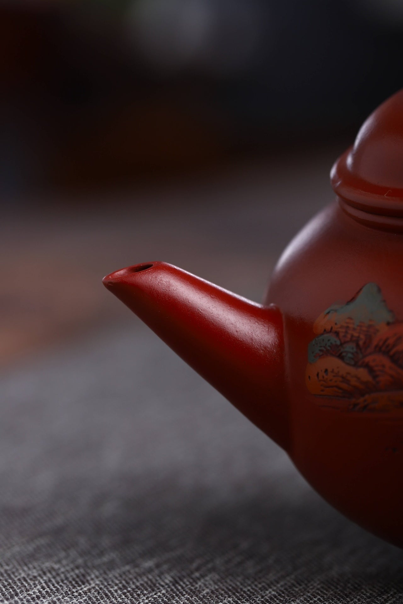 Handmade Yixing purple sand teapot spout with intricate detailing and rich red glaze.