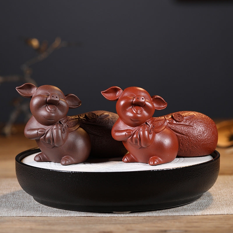 Handmade Zisha tea favors by Yixing craftsman, featuring original purple sand pig figurines in a decorative bowl.