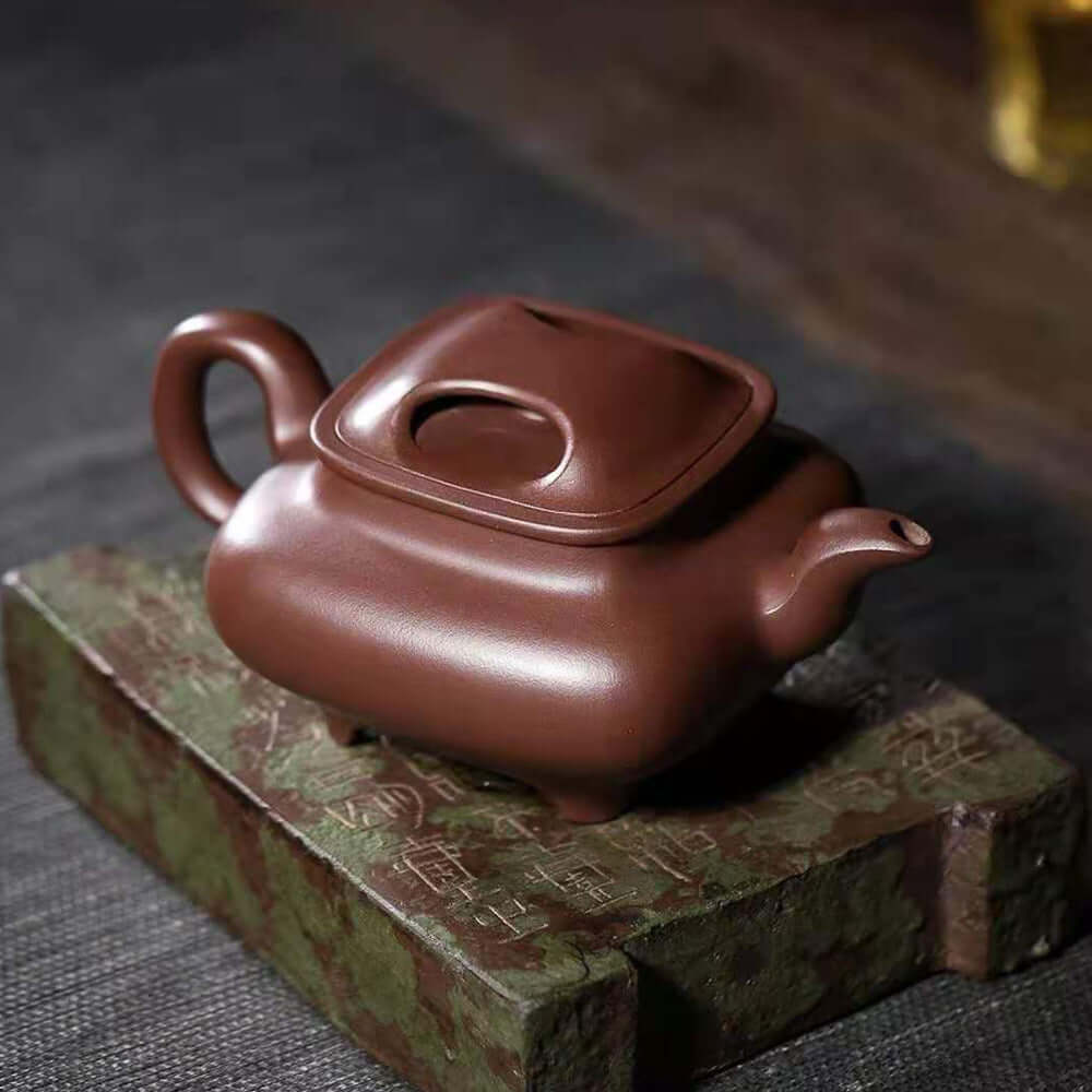 Handmade Yixing purple sand teapot with a square design, perfect for tea enthusiasts and high-end gifts.
