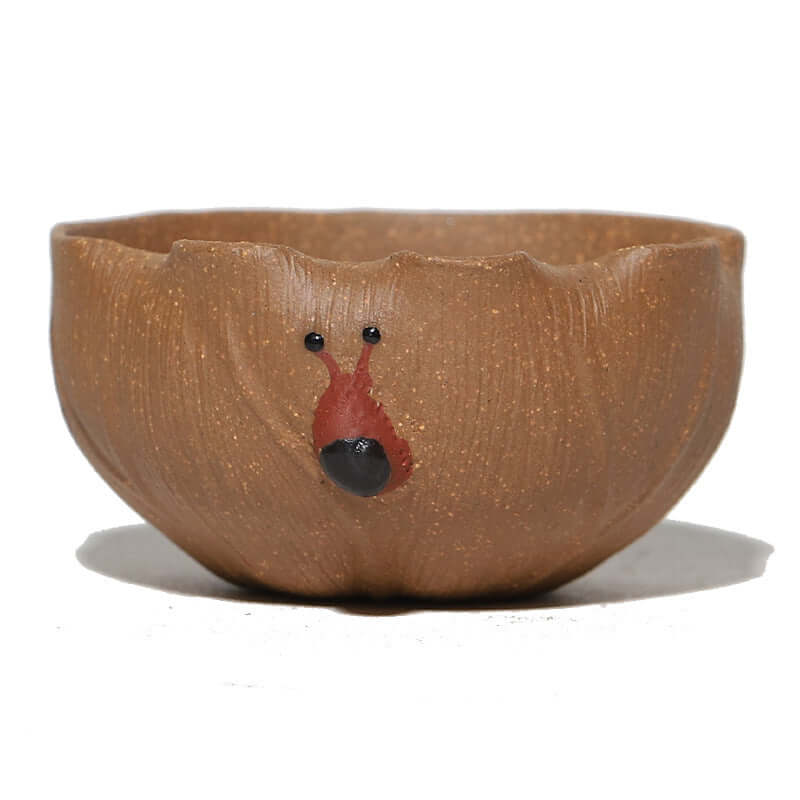Handmade Yixing clay tea cup with a unique snail design, emphasizing artisanal craftsmanship and originality in purple sand.