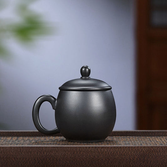 Handmade Yixing purple sand tea cup with a dark green enamel finish, featuring a peony dragon design.