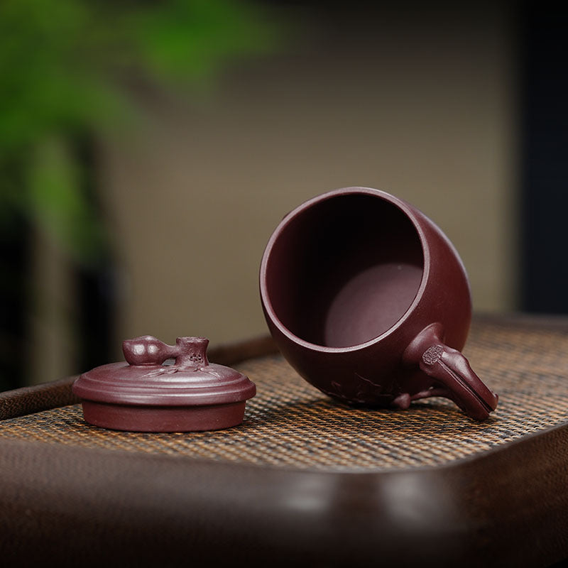 Handmade Yixing purple sand office cup and cover on a wooden tray, showcasing original craftsmanship.