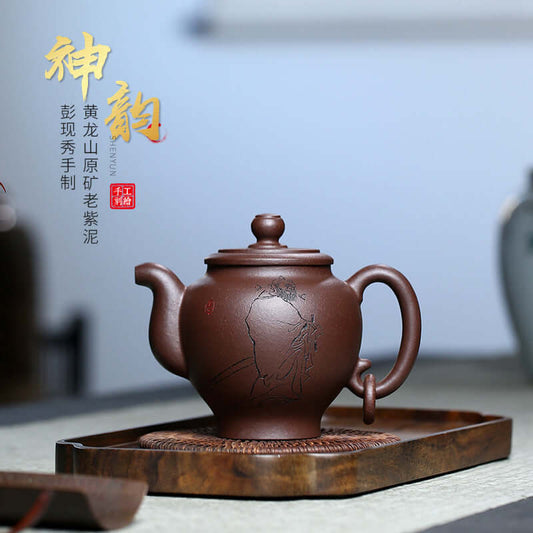Handmade Yixing purple sand teapot with intricate engraving, displayed on a wooden tray, ideal for Kung Fu tea sets.