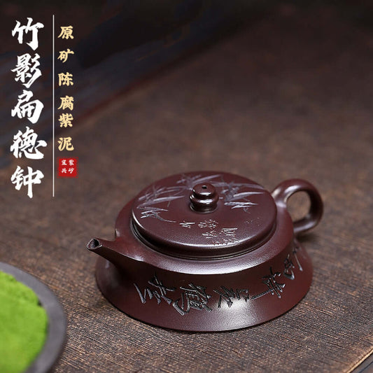 Handmade Yixing purple sand teapot in dark clay, featuring bamboo shadow designs, perfect for kung fu tea ceremonies.