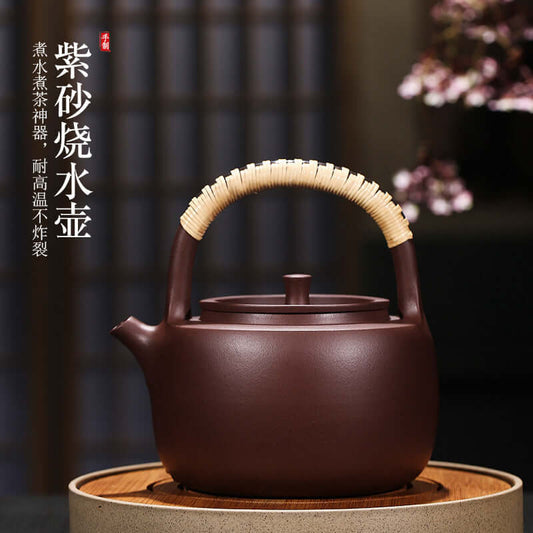 Handmade Yixing purple sand teapot with bamboo handle, high temperature resistant design for tea brewing.
