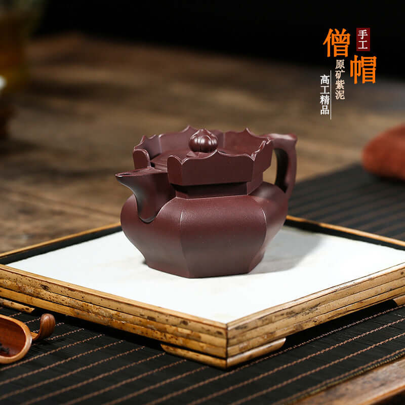 Handmade Yixing purple sand teapot with intricate design, showcasing high-end craftsmanship in a traditional setting.
