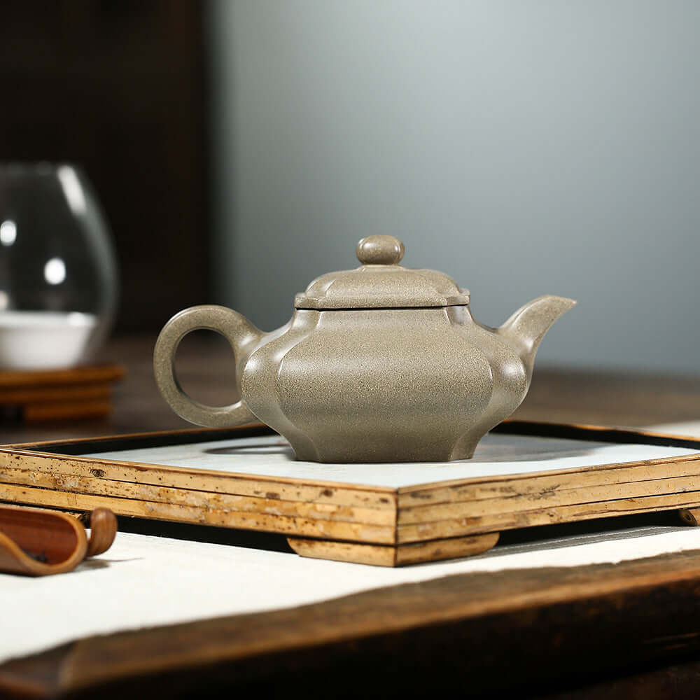 Handmade Yixing purple sand teapot on a wooden tray, showcasing the artisanal craftsmanship in a traditional setting.