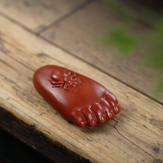 Handmade Yixing purple sand tea pet ornament shaped like a foot, featuring a spider design, crafted for tea enjoyment.