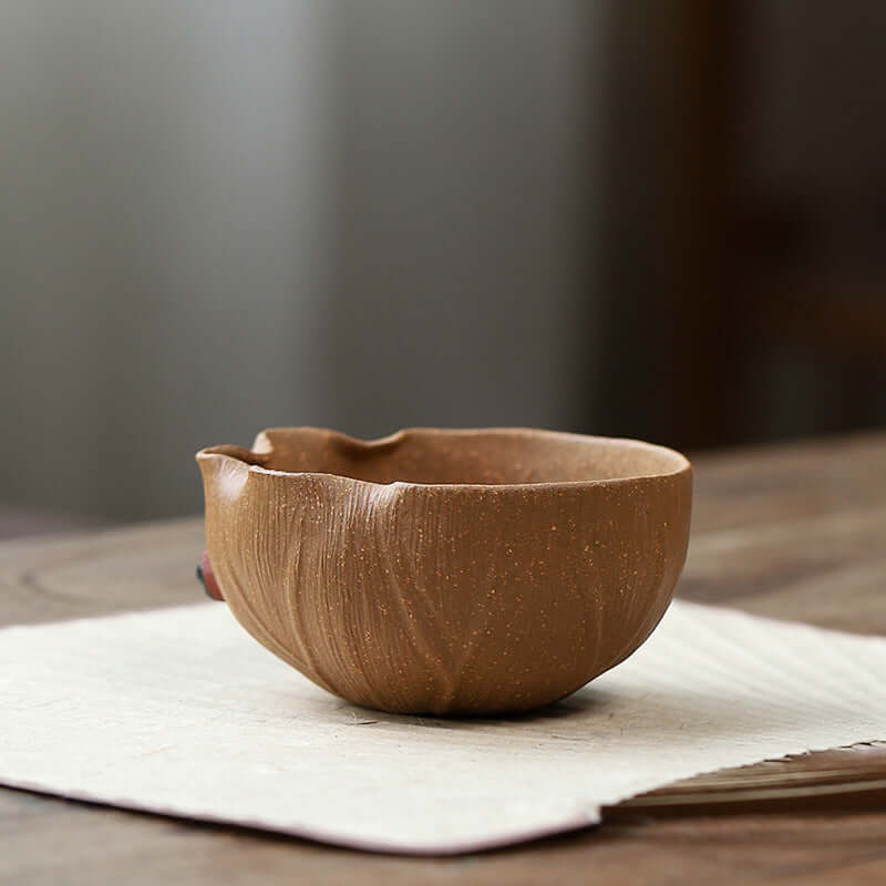 Handmade Yixing golden Duan clay tea cup, showcasing unique texture and design, perfect for Kung Fu tea ceremonies.