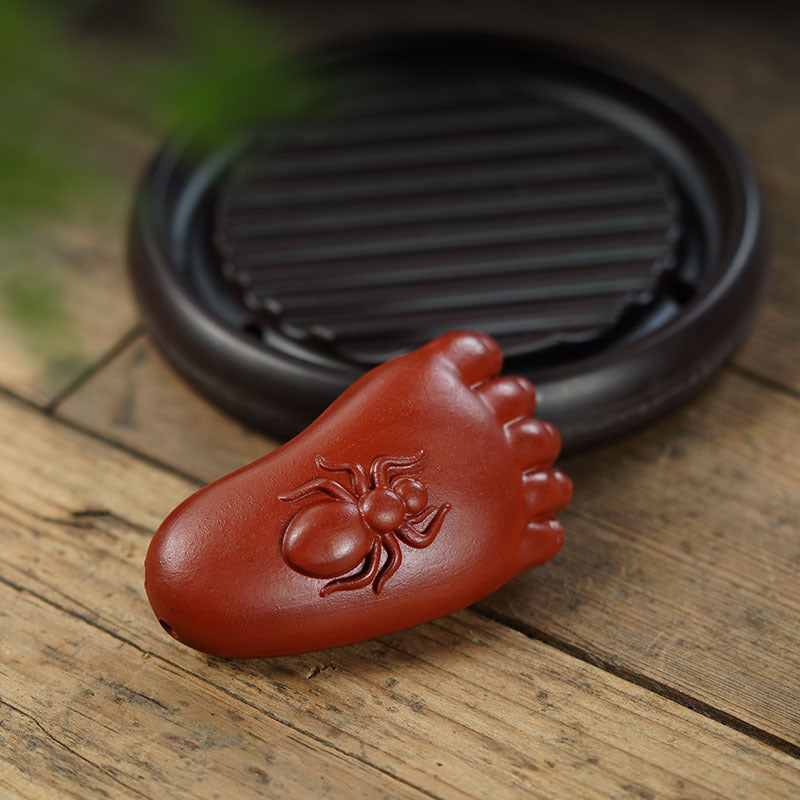 Handmade purple sand tea pet ornament in the shape of a foot with an ant design, ideal for tea lovers and collectors.