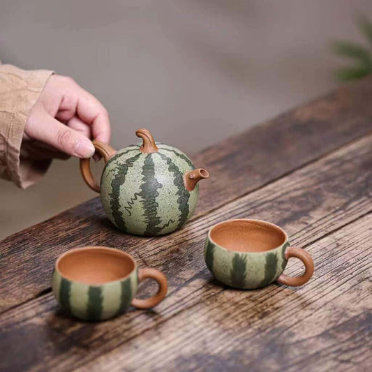 Handmade Yixing purple sand teapot and cups designed as a watermelon, showcasing unique craftsmanship and original design.