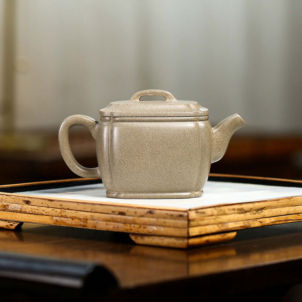 Handmade Yixing purple sand teapot on a tea tray, showcasing high-quality craftsmanship and elegant square design.