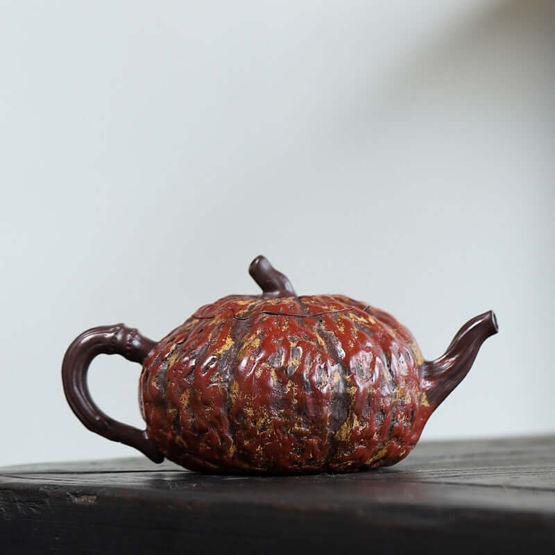 Handmade Yixing purple sand teapot designed as a pumpkin, showcasing intricate texture and colorful glaze.