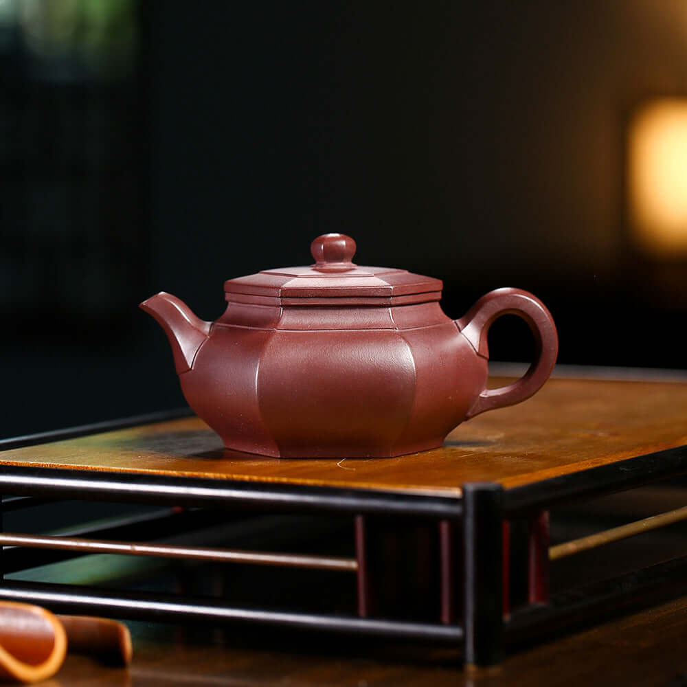 Handmade Yixing purple sand teapot on a wooden tea tray, showcasing traditional craftsmanship and elegant design.