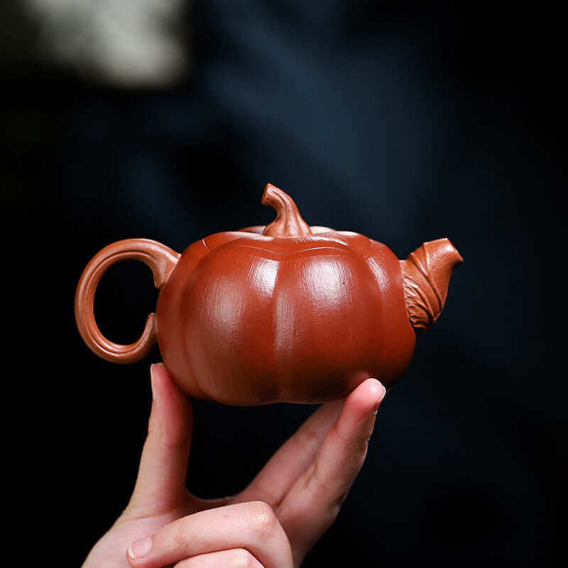 Handmade Yixing purple sand teapot in pumpkin shape, showcasing elegant craftsmanship and unique design.