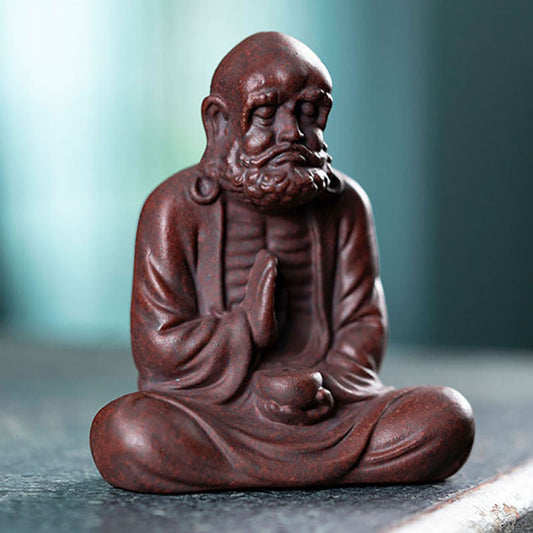 Handmade Yixing purple sand tea pet sculpture, depicting a serene character in meditation, perfect for tea ceremony enthusiasts.