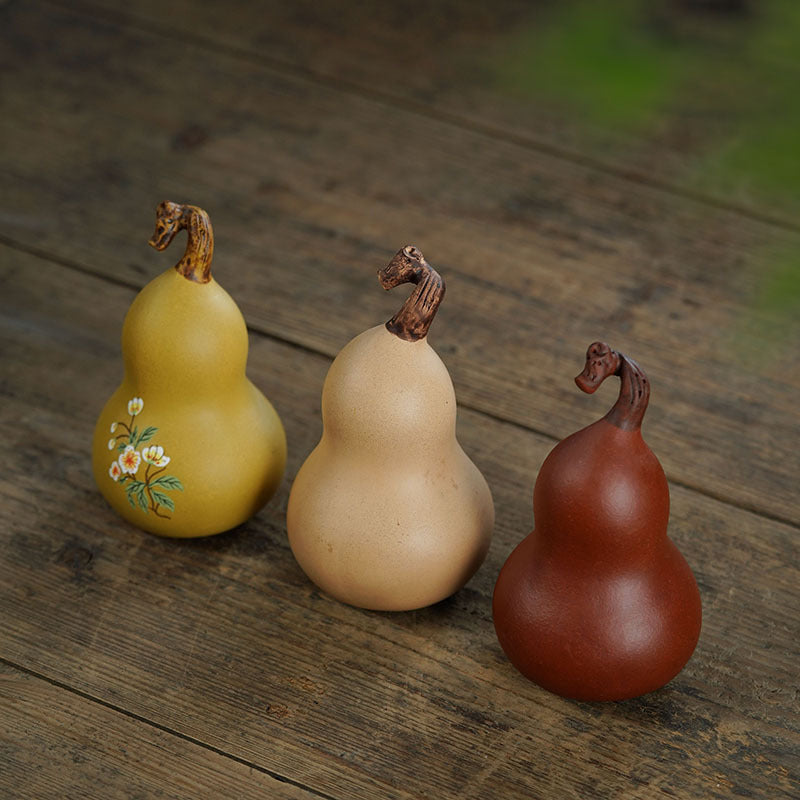 Handmade Yixing purple sand tea pet gourds, crafted by skilled artisans, showcasing unique designs and colors.