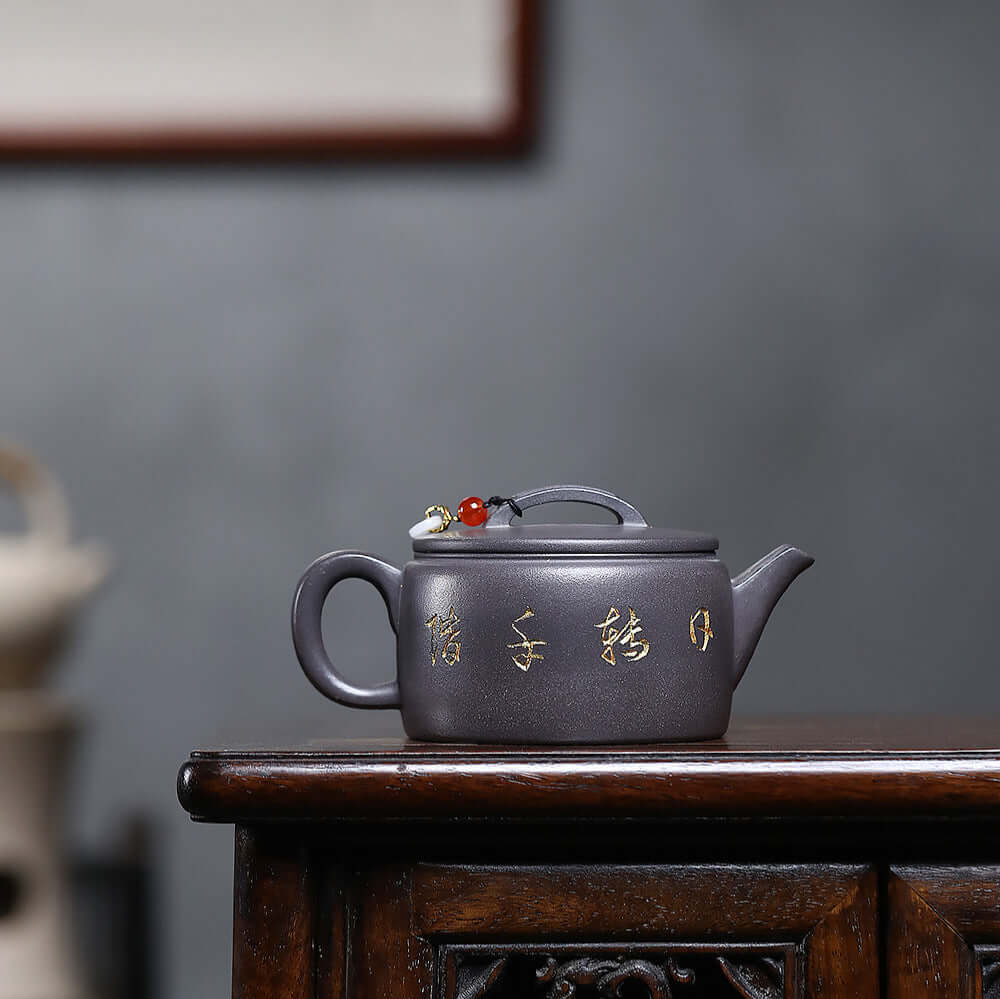 Handmade Yixing purple sand teapot with golden inscriptions, perfect for Kung Fu tea ceremony and home decor.